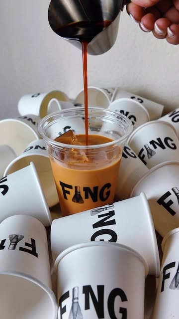 Kaffee wird frisch in einen Fang-Becher mit Eis gegossen